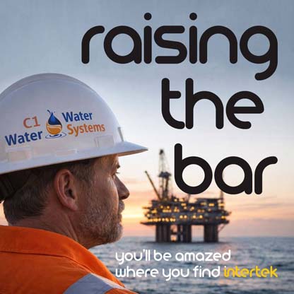 A man wearing a hardhat emblazoned with the C1 Water company logo, looking out at an offshort energy platform