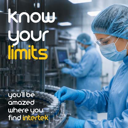 A lab worker wearing PPE while managing vials on a large machine